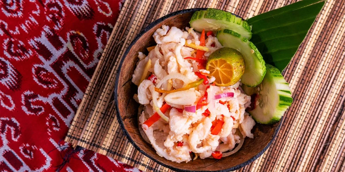 Umai served in a bowl with lime and vegetables