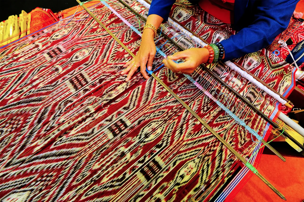 An artisan weaving a patterned Sarawak textile